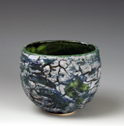 22. Thrown small vessel with multi-glazed reticulated surface & green interior.