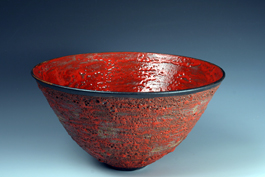 19. Large thrown form with red volcanic exterior and red crawling melt interior.