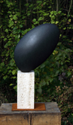 10. Round form, Bursting stone on travertinew base. 71cm high inc base